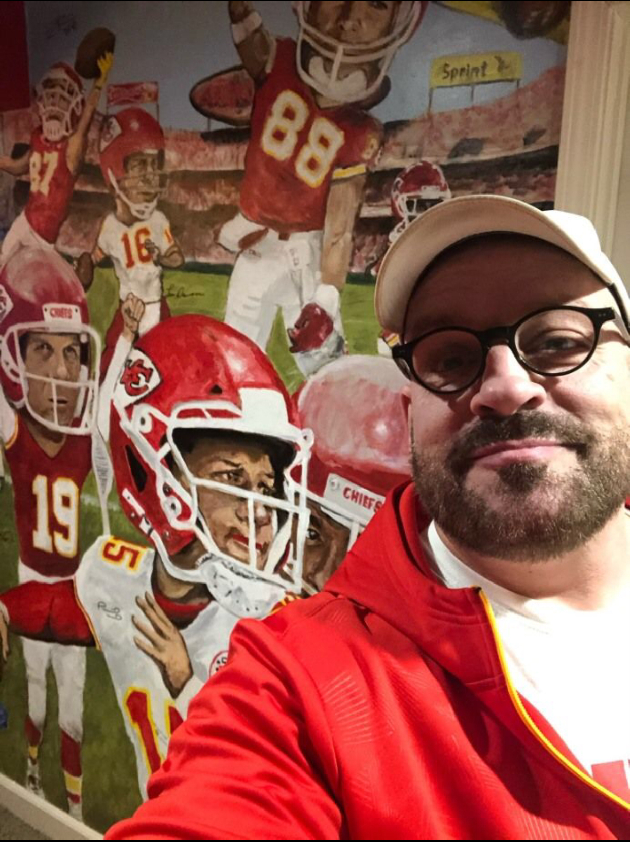 Chris Fleck standing in front of the Parkville extreme man-cave mural